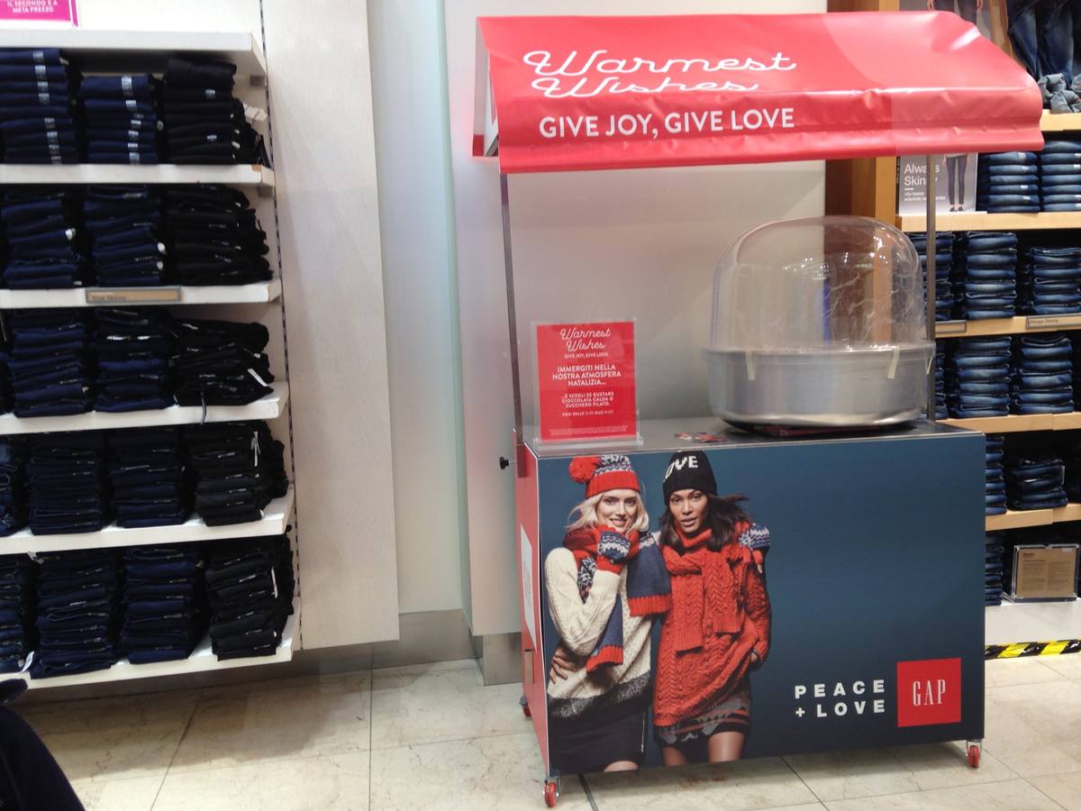 Noleggio carretti alimentari: carretto dello zucchero filato personalizzato con la grafica del brand, dentro il negozio
