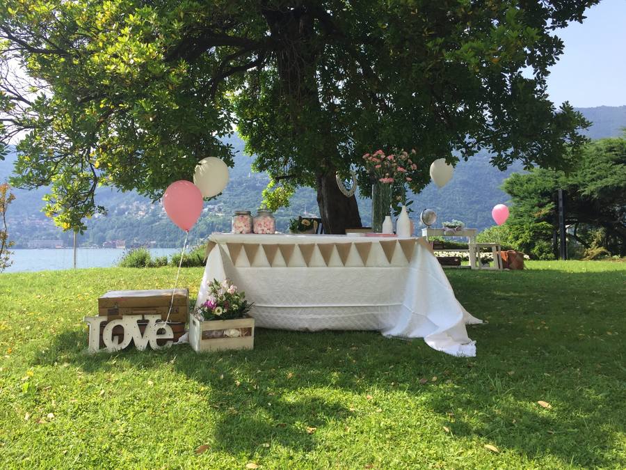 Sweet table con palloncini e scritta Love in un giardino sul lago